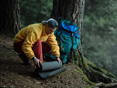 A man setting up camp by the shore