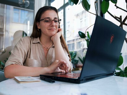 Young woman using a laptop while sitting at a café table
