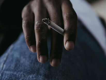 Held firmly in hand, the cigarette reflects a broader public health challenge that continues to claim lives and harm the environment