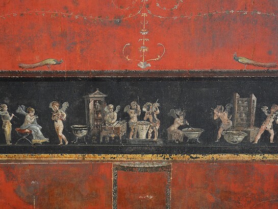 Affresco nella Casa dei Vettii rappresenta degli amorini profumieri che azionano una pressa per l'estrazione dell'olio mediante lunghi martelli, mentre una psyche mescola un recipiente posto sul fuoco e, presso un bancone con rotolo forse per i conti o con le ricette dei profumi, e bilancia, un cliente testa l'essenza sul dorso della mano. Regio VI, insula 15, civico 1. Pompei, Italia