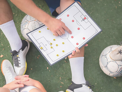 Coach instructing players in football tactics during training session