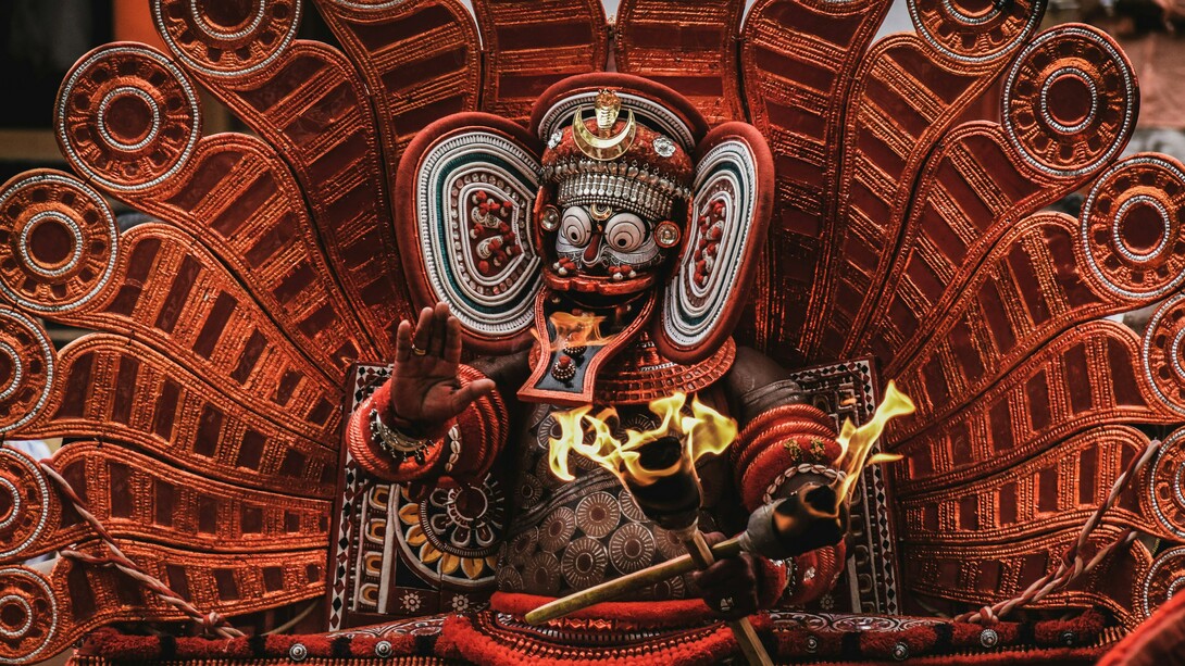 Theyyam, a vibrant Hindu ritual featuring red-and-white deities, is practiced in the North Malabar region of Kerala and parts of Karnataka