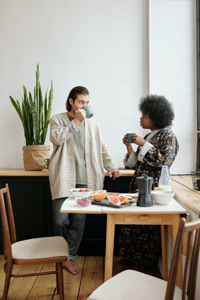Two people drinking coffee and eating fruit 