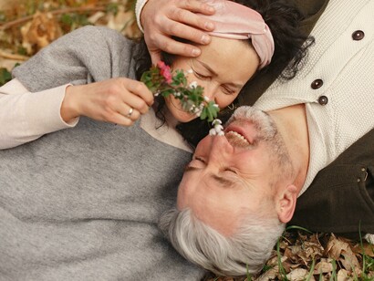 A couple laying together on the ground.  
Love in older age is a testament to the enduring power of human connection