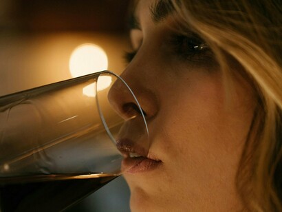 Mulher bebe uma taça de vinho. Uma de
suas metas era tirar o paladar dito por ela infantil e treiná-lo para o gosto da
morte amarga dos vinhos secos e dos cafés pretos sem açúcar