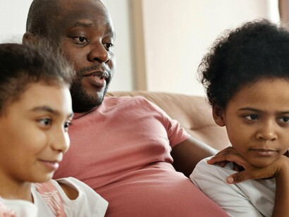 Pai assiste programa com filhos. Lembrei-me dos eternos minutos que antecedem a seleção de um filme para ser assistido em família, já que temos apenas uma televisão. Esta fica na sala, onde temos o espaço familiar e a obrigação de chegar a um acordo sobre qual programação a ser vista, quase sempre via processos democráticos (exceto quando os ditadores mirins atuam em conjunto e as forças adultas já estão tão desgastadas que preferem ceder sem lutar)