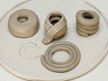 Peças de argila modeladas manualmente revelam diferentes maneiras de enrolar, sobrepor e organizar os cordões, formando volumes e contornos variados. No acordelado, cada camada acrescentada participa da construção da peça, em um processo que combina técnica, paciência e liberdade criativa