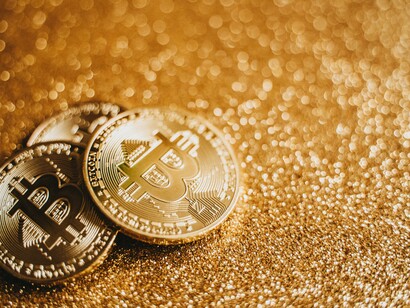 Three bitcoins on a gold background 