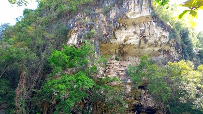 Aldea en el distrito de Simbang, regencia de Maros. Respecto a sus características geológicas, es una cueva de piedra caliza de la formación Tonasa. En la terraza de la cueva se encuentran varias conchas de moluscos, restos de los desechos de cocina de los humanos prehistóricos que habitaron la cueva. Rodeada de frondosos árboles verdes, quién hubiera pensado que, Leang Karampuang o la cueva Karampuang, alberga el archivo de narrativa y pinturas rupestres más antiguo del mundo, con 51.200 años de antigüedad. Sulawesi del Sur, Indonesia