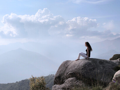 A woman taking in the mountain view, symbolizing the powerful relationship between movement, mindfulness, and inner peace