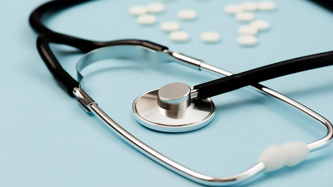 Stethoscope and pills arranged on a serene blue background, symbolizing the essential elements of modern healthcare and medical treatment