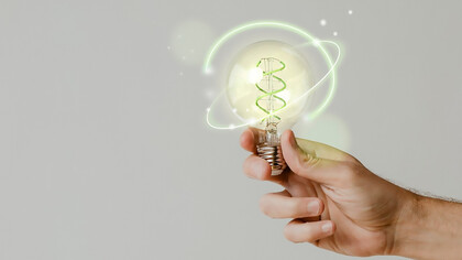 Green energy with hand holding an environmental light bulb 