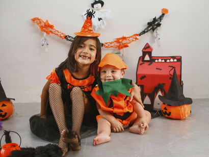 Dos niños disfrazados con motivos clásicos de Halloween: una bruja y un calabaza