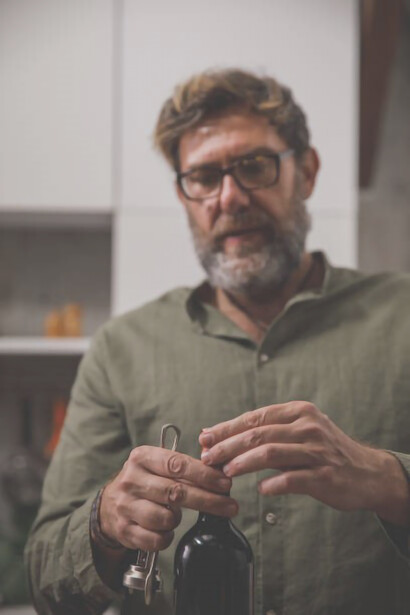 With precision, the man extracts the wine cap from the bottle