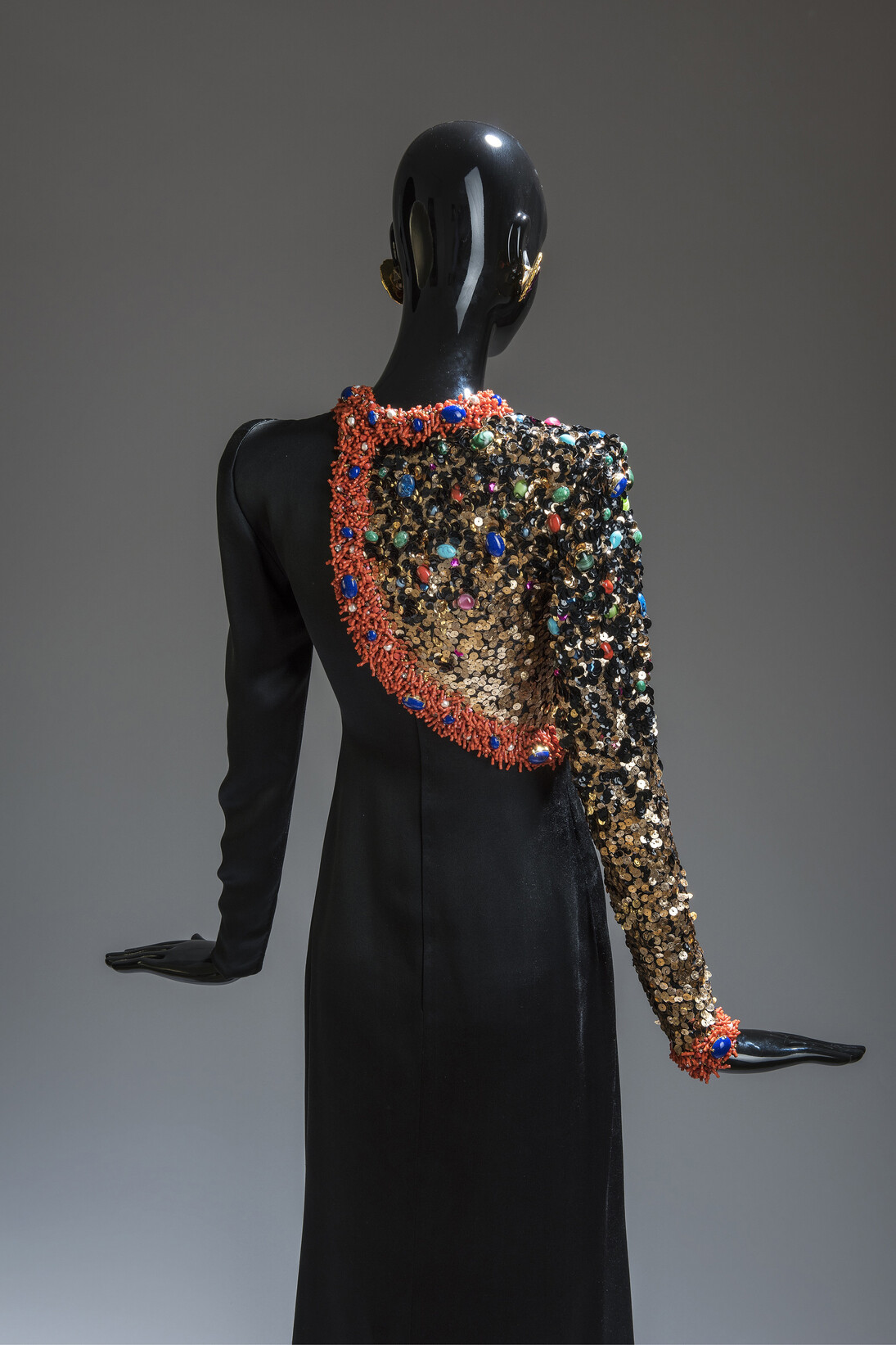 Black satin sheath evening dress; semibolero effect bodice embroidered with gold and black paillettes and multi-coloured stones, edged with Rosalind coral. Winter 1991. Maison Givenchy. Foto: Luc Castel con la colaboracion de Philippe Caron