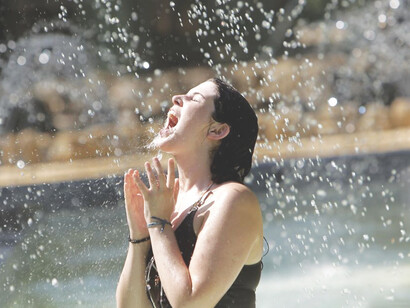 Mujer bajo una fuente de agua. «En un cierto umbral de calor y humedad, ya no es posible sudar lo suficientemente rápido para evitar el sobrecalentamiento»