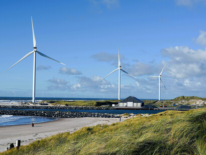 In Hvide Sande, Denmark an idyllic beach landscape is complemented by wind turbines, showcasing the integration of renewable energy into the natural environment