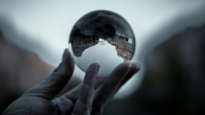 A hand cradling the world, representing care for global issues and environmental stewardship