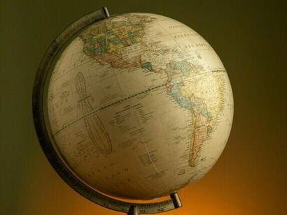 Un globo terráqueo que se yergue silenciosamente bajo una luz cálida, reflejando la búsqueda mundial de un orden más equilibrado y democrático