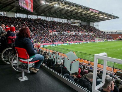 Disabled fans of the sport of football watch their team on in their home stadium at Stoke City FC from a designated area not far from the pitch