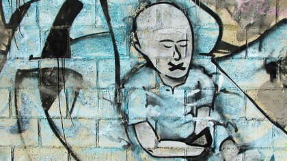 A man painted in blue graffiti, symbolizing censorship, silence, and the emotional toll of cancel culture and social oppression