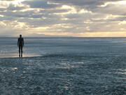 Antony Gormley  Another Place, 1997, Antony Gormley’s Another Place features 100 cast-iron figures facing the sea along Crosby Beach, exploring humanity’s relationship with nature, time, solitude, and existence. Each life-sized figure, modelled on Gormley’s own body, stands motionless against shifting tides and weather, symbolizing reflection, resilience, and the universal human search for meaning and connection
