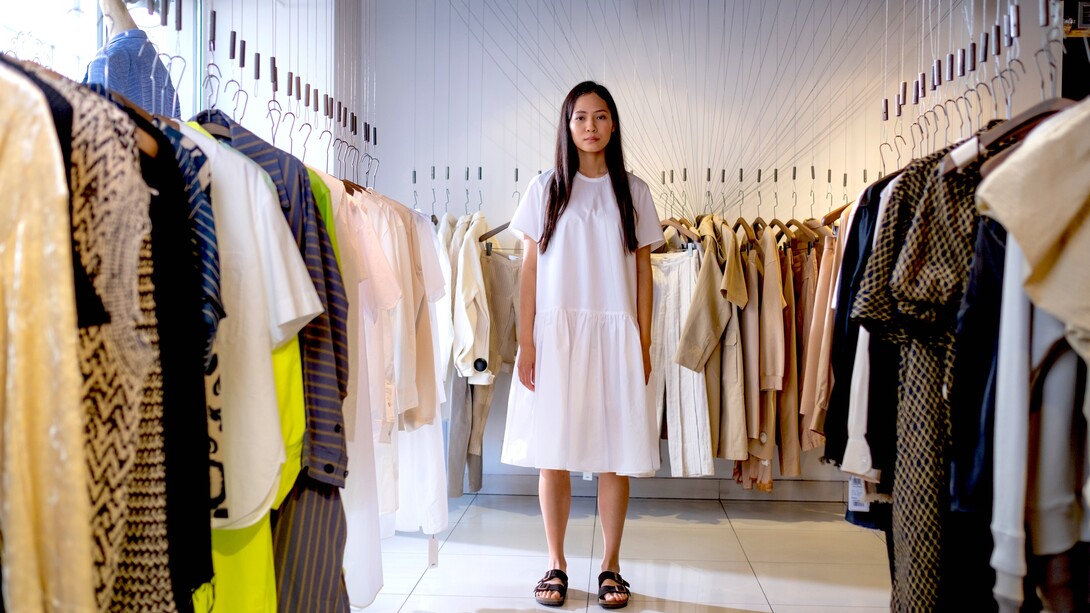 Mulher com vestido branco e sandálias em brechó