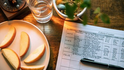 A plate of fresh fruit beside a calorie and nutrition chart, representing the role of food security in protecting health and development