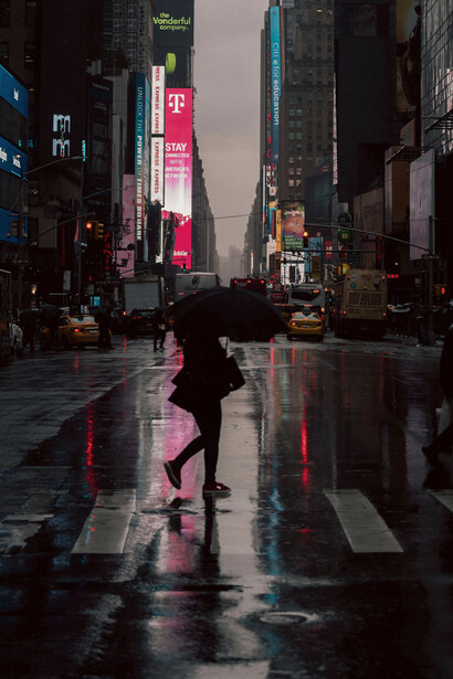 A woman crosses the street with an umbrella in New York City, United States