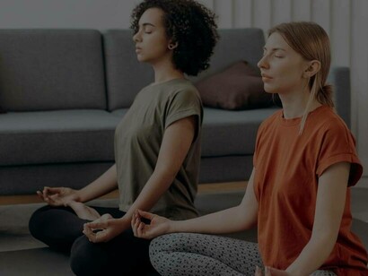 Two women meditating as they try to remain persistent in strife 