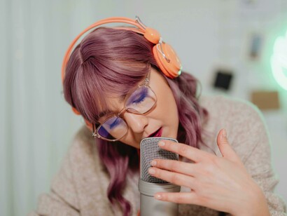 A woman speaking into a microphone during a podcast, symbolizing the rise of online communities, digital town halls, and the evolving public square