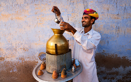 Street vendor preparing and serving masala chai in Jaipur, India
