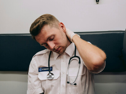 Profissional da saúde com sintomas de Burnout. Exaustão física e mental: o esgotamento crônico leva à perda de energia, fadiga constante e dificuldade de concentração, afetando a qualidade do trabalho e a segurança dos pacientes