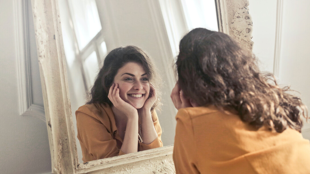 Sorriso no rosto e autoadmiração no espelho 