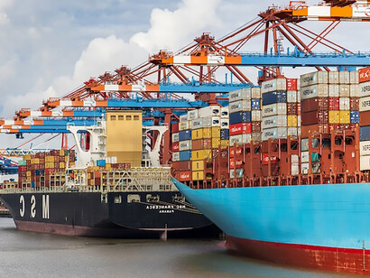 In the daylight off the coast of Hamburg, Germany, a striking blue and red cargo ship plies the waters