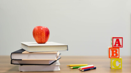 Red apple fruit on four pyle books