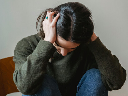 A woman in a sweater holding her head low