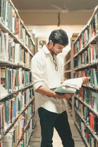 A man reading a book in a library 