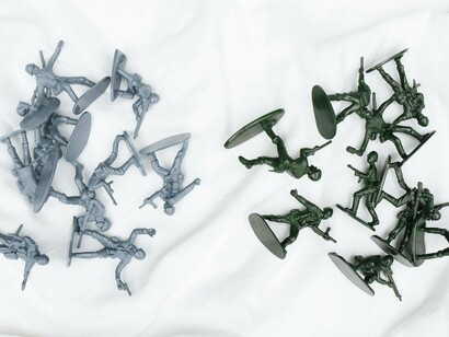 Plastic toy soldiers arranged in scattered positions, reflecting the influence of military on regional tensions