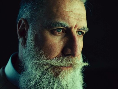 A man looking intensely into someone after doing the Keratopigmentation procedure and getting darker green eyes