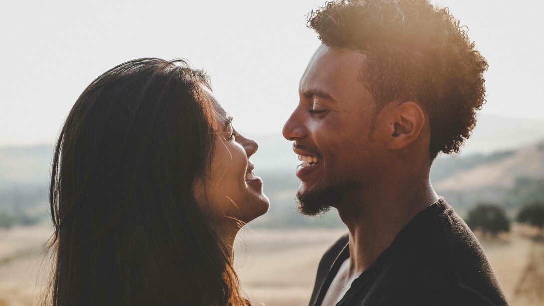 Man and woman gaze at each other by the beach
