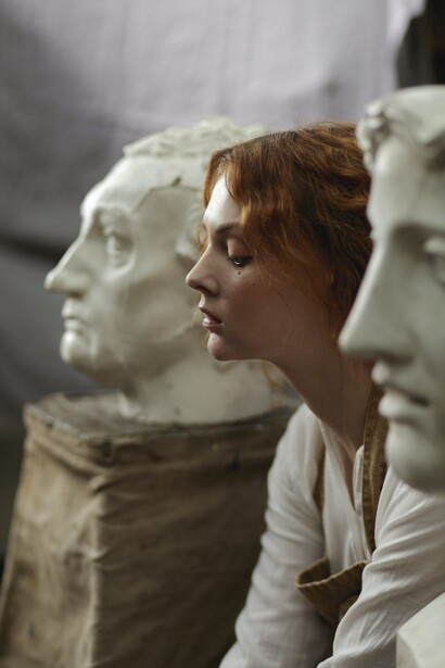 An artist's face between two statues. We seek to imagine the brightest of scenarios