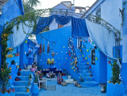 A colourful courtyard surrounded by cobalt walls in Tangier, Morocco, symbolising the joyful spirit that flourishes within the city's timeless architecture