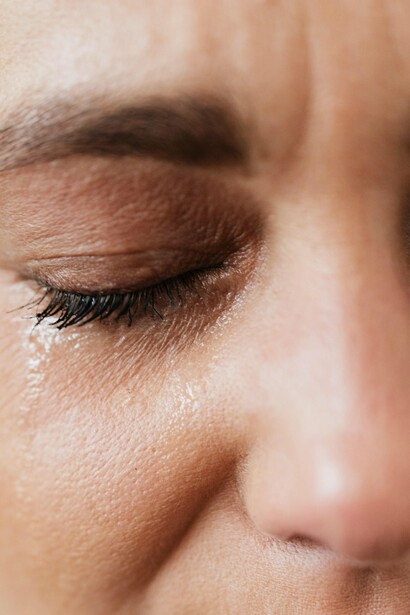 Woman with eyes shut and tears