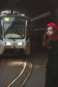 A woman standing in front of a train in a tunnel, ready for her next adventure as a traveler