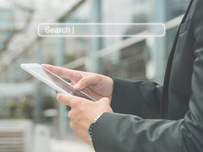 A person using their phone with a search bar displayed, showcasing AI search results and Google’s search engine technology integration