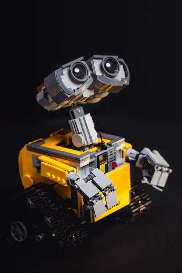 The yellow and gray robot toy evokes the emotional tension between artificial intelligence and the human experience of grief