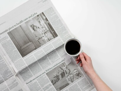 A newspaper resting beside a warm drink, symbolizing how public opinion is constructed through stories that extend far beyond the pitch