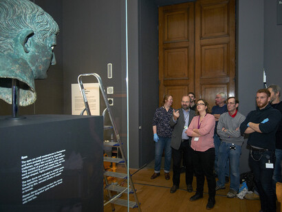 Curator and exhibition team overseeing installation of the Meroë head of Augustus in Room 3 at the British Museum © The Trustees of the British Museum