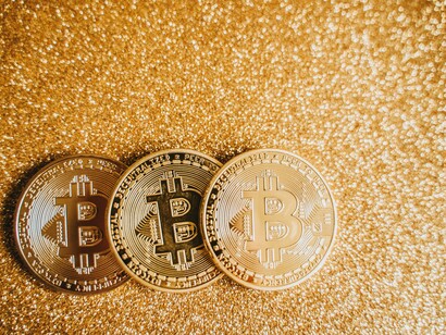 Three bitcoins on a gold background 